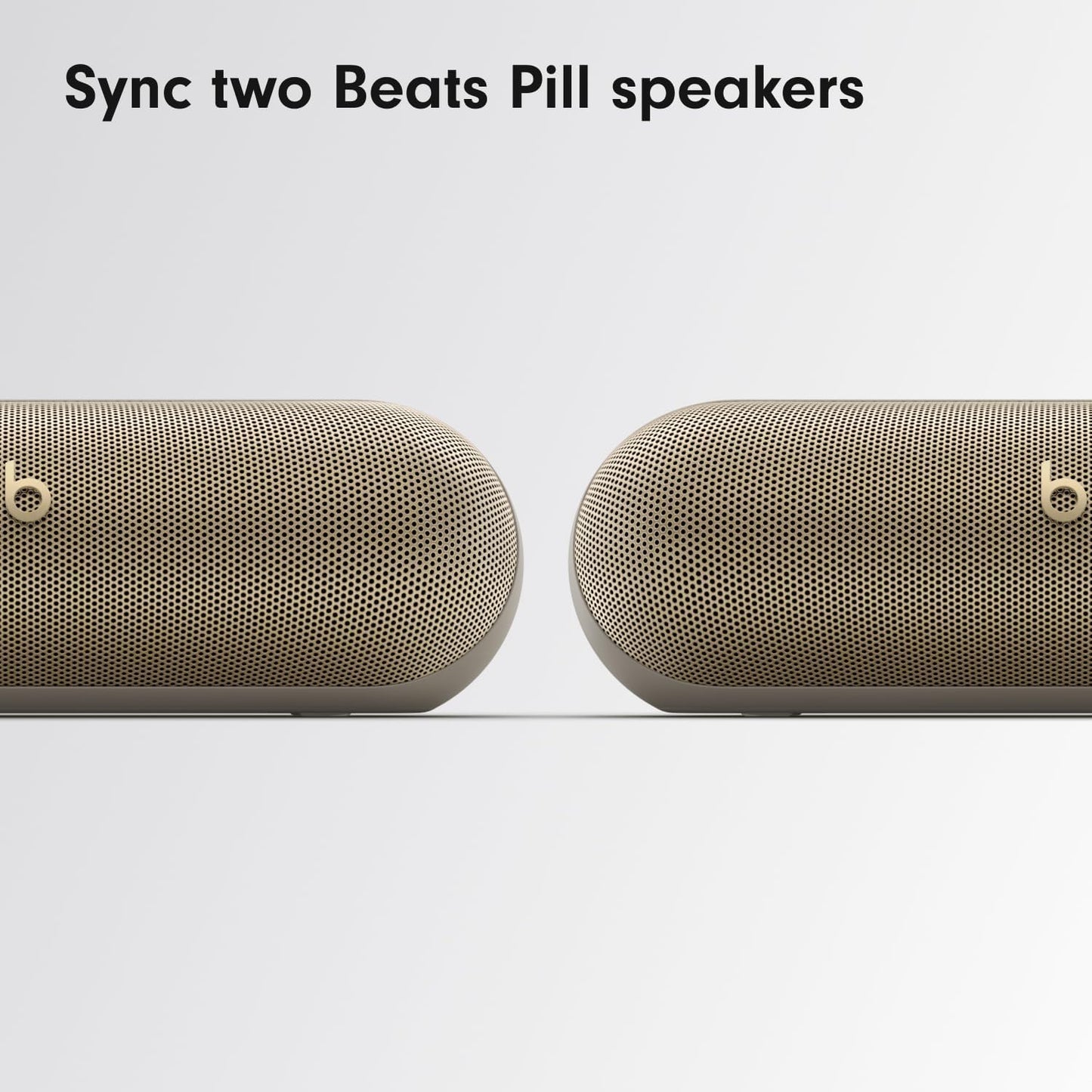 Two Beats Pill Bluetooth Speakers in Gold Syncing for Enhanced Sound Experience