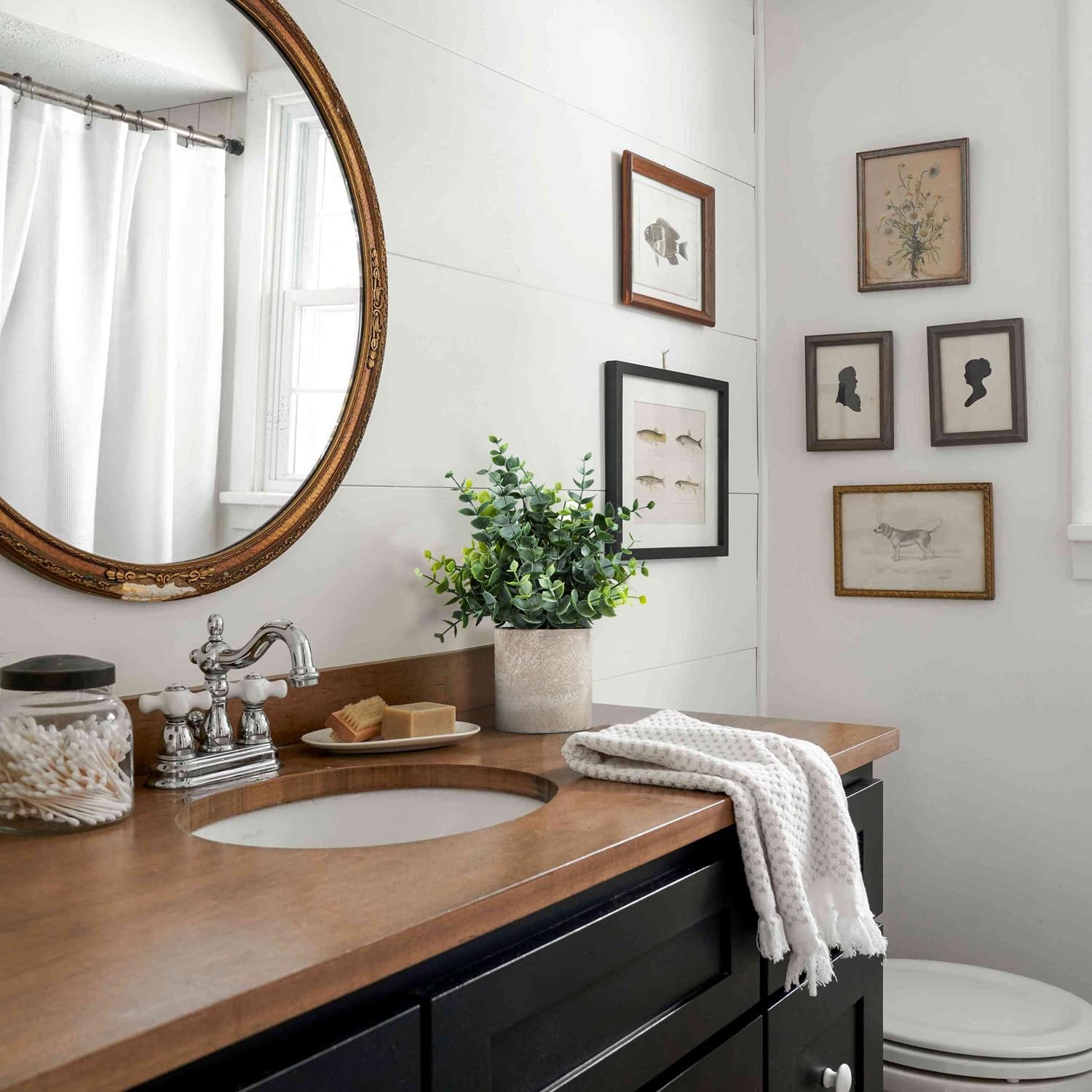 Artificial eucalyptus plants in a decorative pot on a bathroom vanity with modern decor
