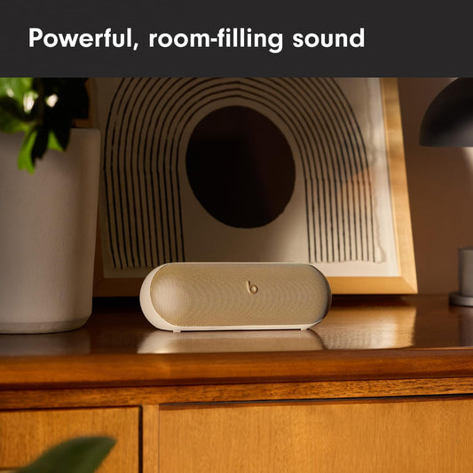 Beats Pill Bluetooth Speaker in Cream Color on Desk with Artistic Background for Powerful Sound